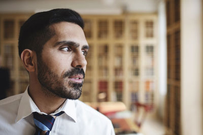 Close-up of male lawyer looking away in library