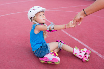 Full length of girl practicing with roller skates in field