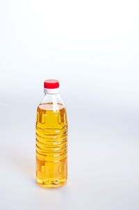Close-up of cooking oil in bottle over white background