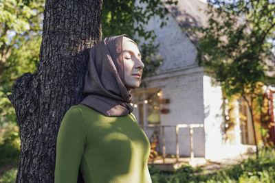 Portrait of woman standing against trees