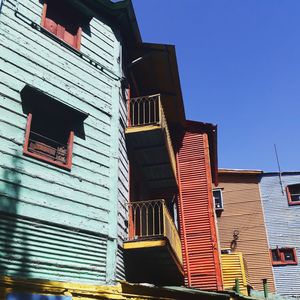 Low angle view of residential buildings against clear blue sky