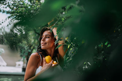 Portrait of young woman holding food outdoors