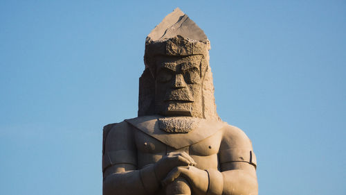 Low angle view of statue against clear blue sky