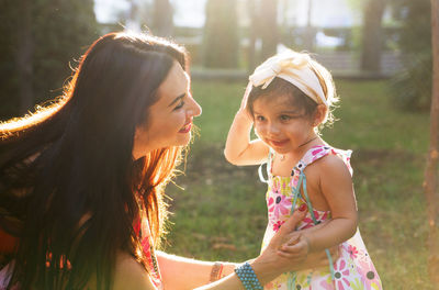 Happy mother and daughter in the park. beauty nature scene with family outdoor lifestyle. 