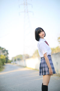 Side view full length of woman standing against sky