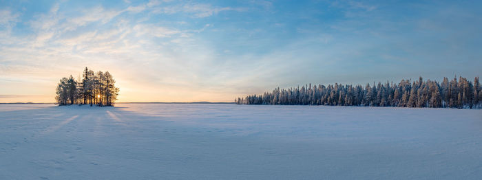 Scenic view of frozen landscape against sky during winter