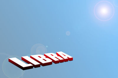 Low angle view of sign against clear blue sky