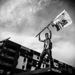 Low angle view of man jumping against sky