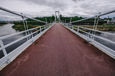 Footbridge over road against sky