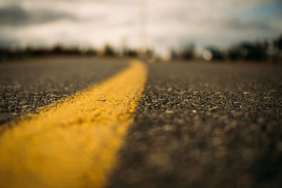 Low angle view of yellow divider line on city road.