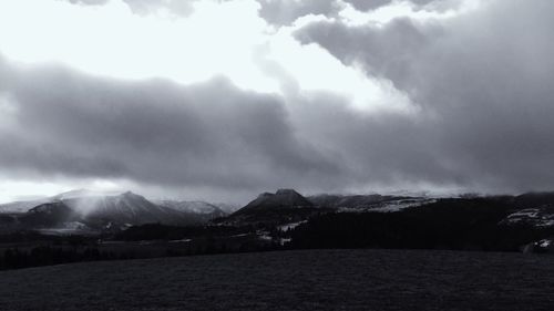 Scenic view of mountains against cloudy sky