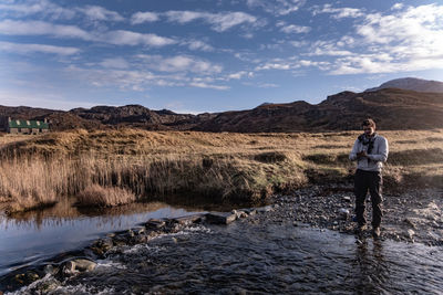 Man standing on mountain against sky