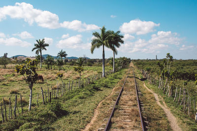 Panoramic view of railroad tracks on field against sky