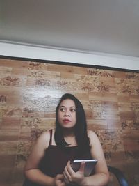 Portrait of young woman using mobile phone at home