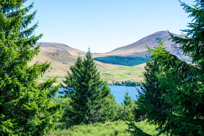 Scenic view of landscape and mountains against clear blue sky