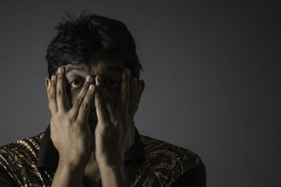 Portraiture of a man in low light with a messy hair and try to look for something in front of him