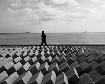 Full length of man standing on sea shore against sky