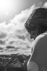 Portrait of woman with arms raised against sky