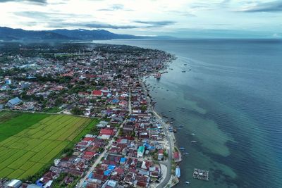 High angle view of townscape by sea against sky
