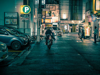 People on street in illuminated city at night