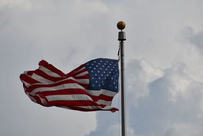 Low angle view of american flag against cloudy sky