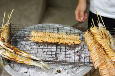 Close-up of person preparing food on barbecue grill