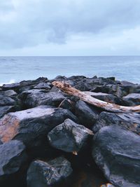 Rocks on sea shore against sky