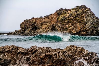 Scenic view of rocks in sea against clear sky