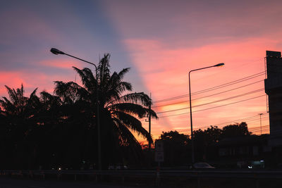 Silhouette palm trees against sky during sunset