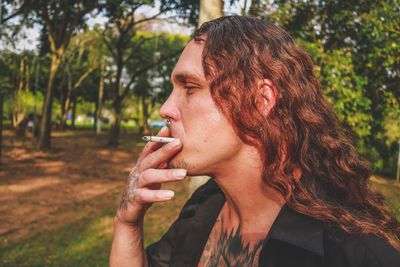 Close-up hipster man smoking at park