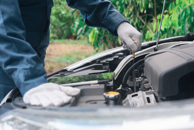 Midsection of mechanic repairing car