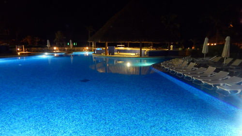 Illuminated swimming pool against sky at night