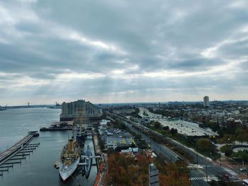 High angle view of city buildings against cloudy sky