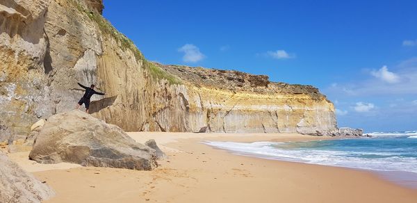 Rock formations on beach against sky