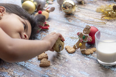 Close-up of girl playing with toy while lying down on wooden flooring