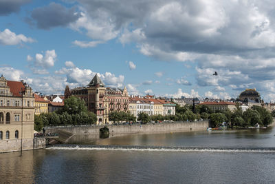 View of town by river against sky