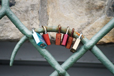 Close-up of love locks on railing against stone wall