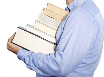 Midsection of man carrying books against white background