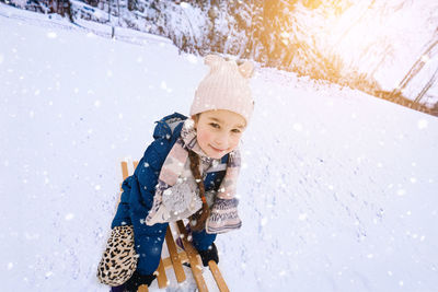 Portrait of young woman standing on snow