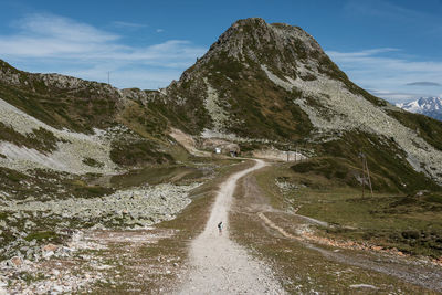 Scenic view of road by mountain against sky