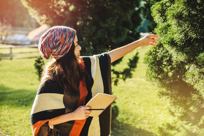 Rear view of woman standing against trees