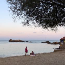 People at beach against sky