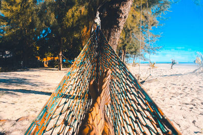 Low section of woman relaxing in hammock at beach