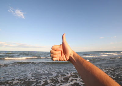 Midsection of person against sea against sky