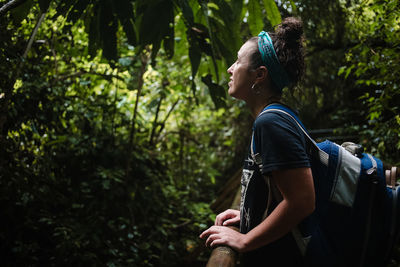 Side view of woman looking at forest