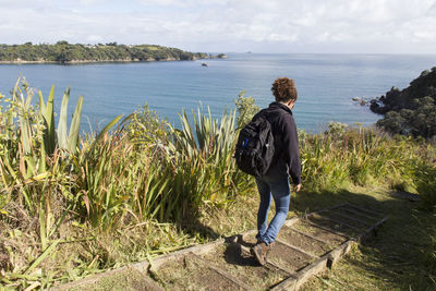 Rear view of woman looking at sea against sky