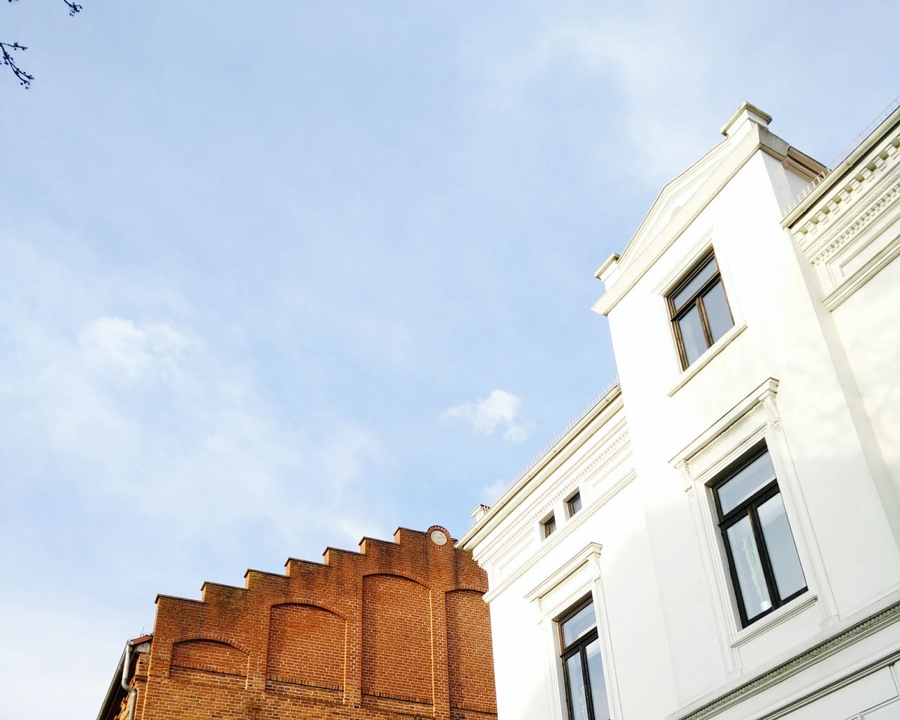 low angle view, building exterior, architecture, built structure, sky, window, high section, building, cloud, cloud - sky, residential building, day, blue, residential structure, outdoors, no people, house, city, sunlight, facade