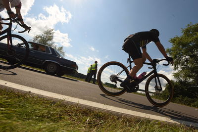 Man riding bicycle on road against sky