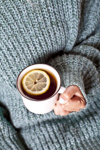 High angle view of woman holding coffee on table