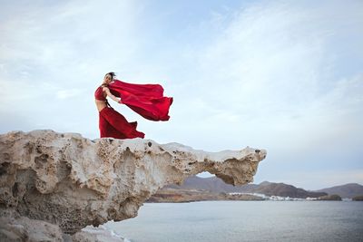 Woman in red dress on rock formation